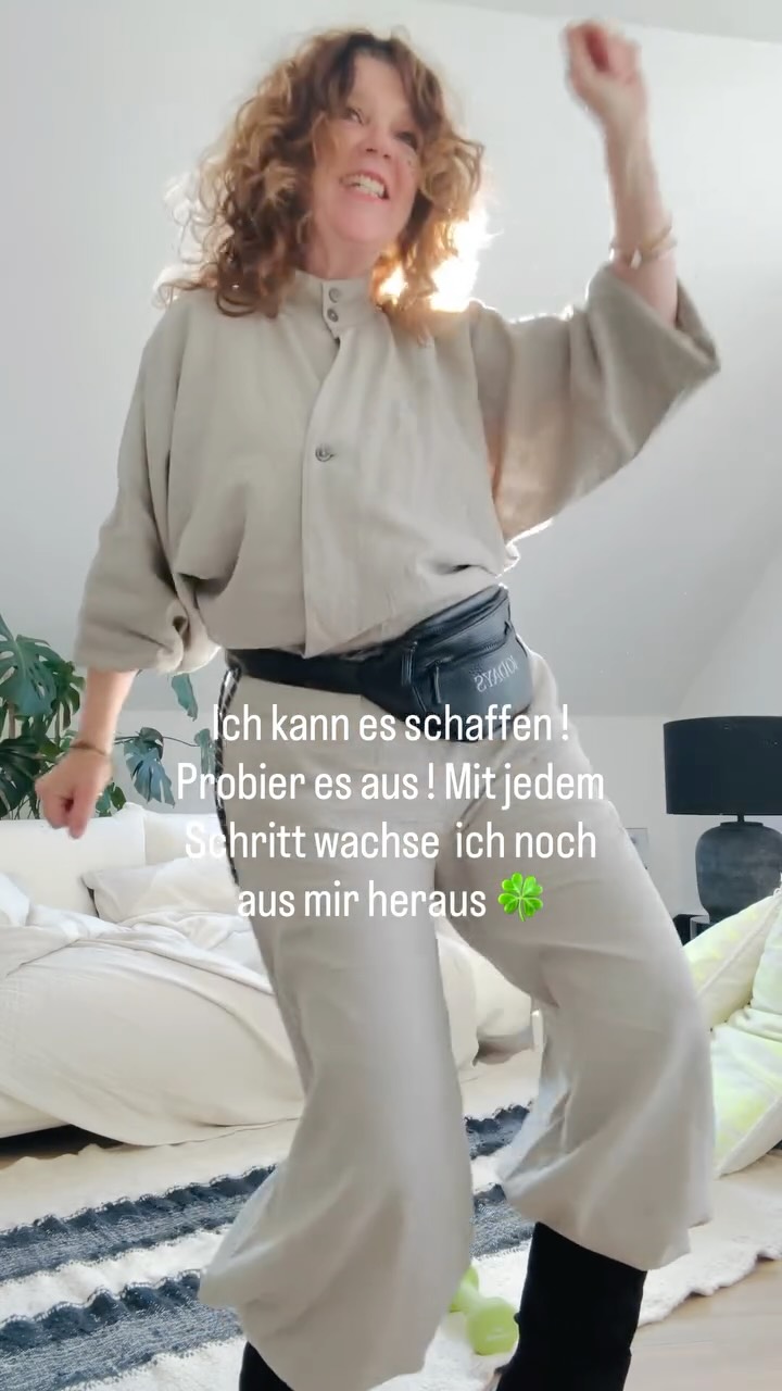CEE trägt ein weiches, fließendes 10Days Outfit in gedeckten Farbtönen und schaut in den Spiegel – entspannter Alltagslook mit hochwertigen Materialien.