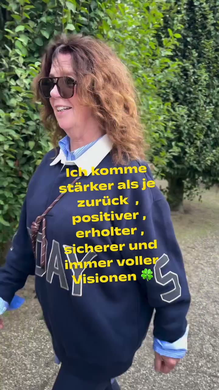 CEE im dunkelblauen 10DAYS-Sweatshirt mit hellblauem Hemdkragen und Sonnenbrille bei einem Spaziergang im Grünen.